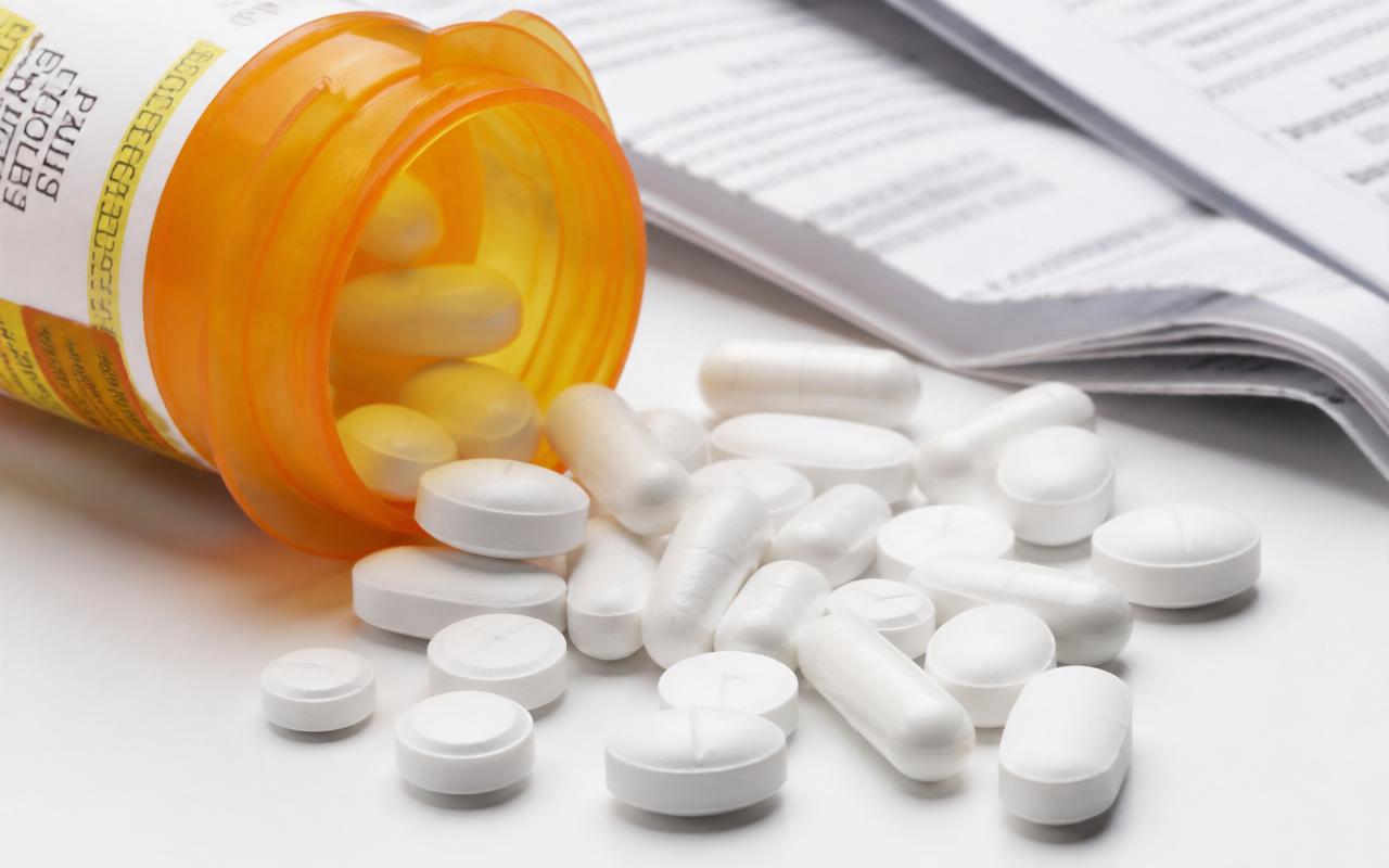Prescription pills spilling from an amber pharmacy bottle